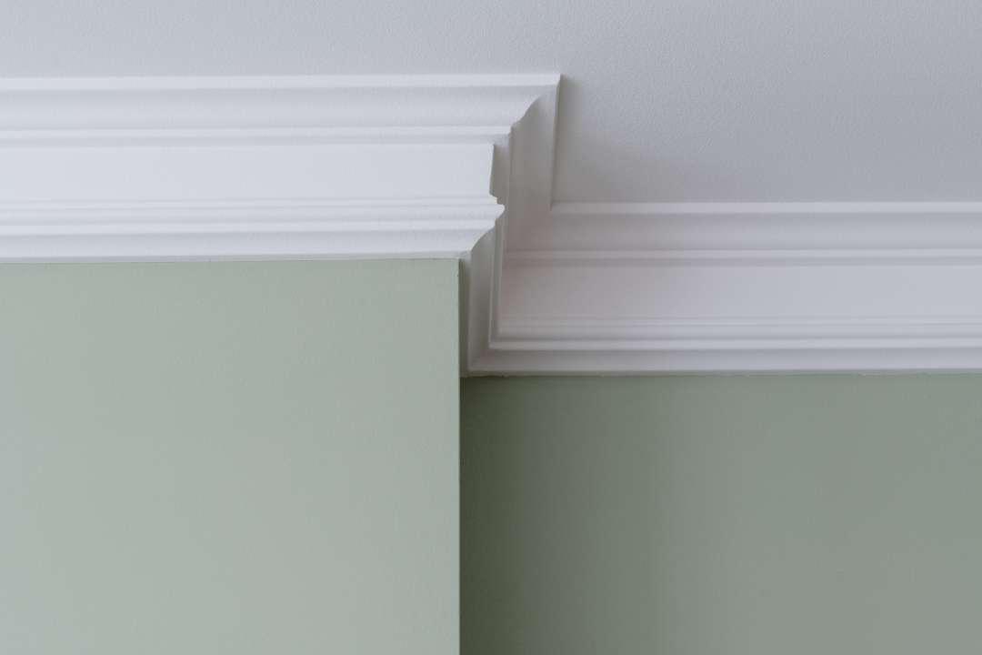 White crown molding on a green wall