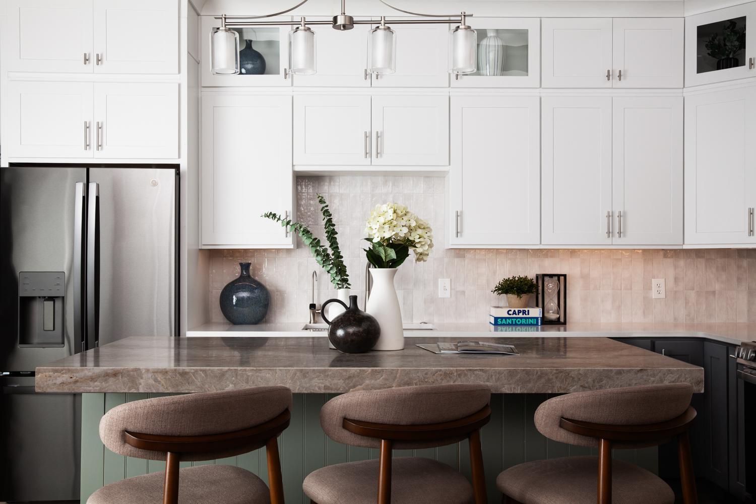 Showroom kitchen display with white cabinets and green island.