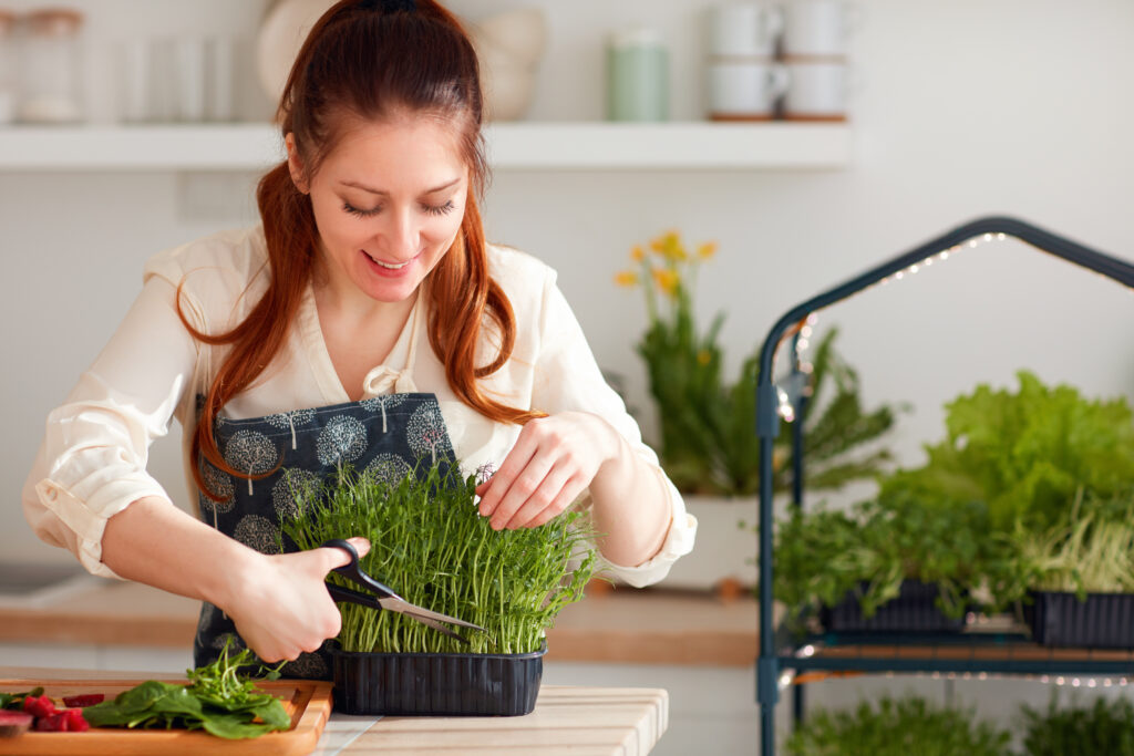 Woman cutting fresh herbs in her natural kitchen.