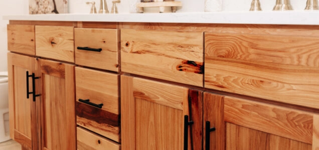 Close up of a bathroom double sink vanity cabinet in a blonde wood with its natural wood grain pattern on display