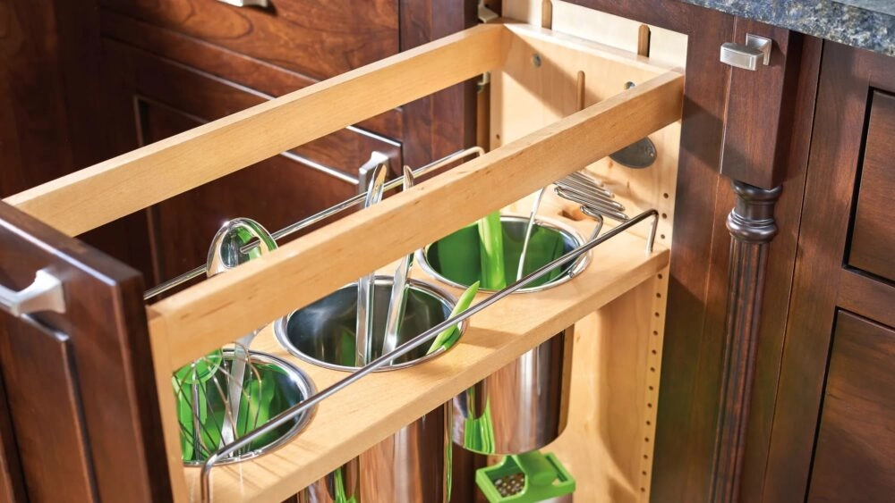 Close up of an opened cabinet pull out organizer with containers for kitchen utensils