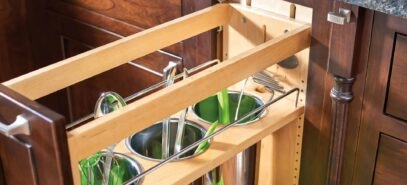 Close up of an opened cabinet pull out organizer with containers for kitchen utensils