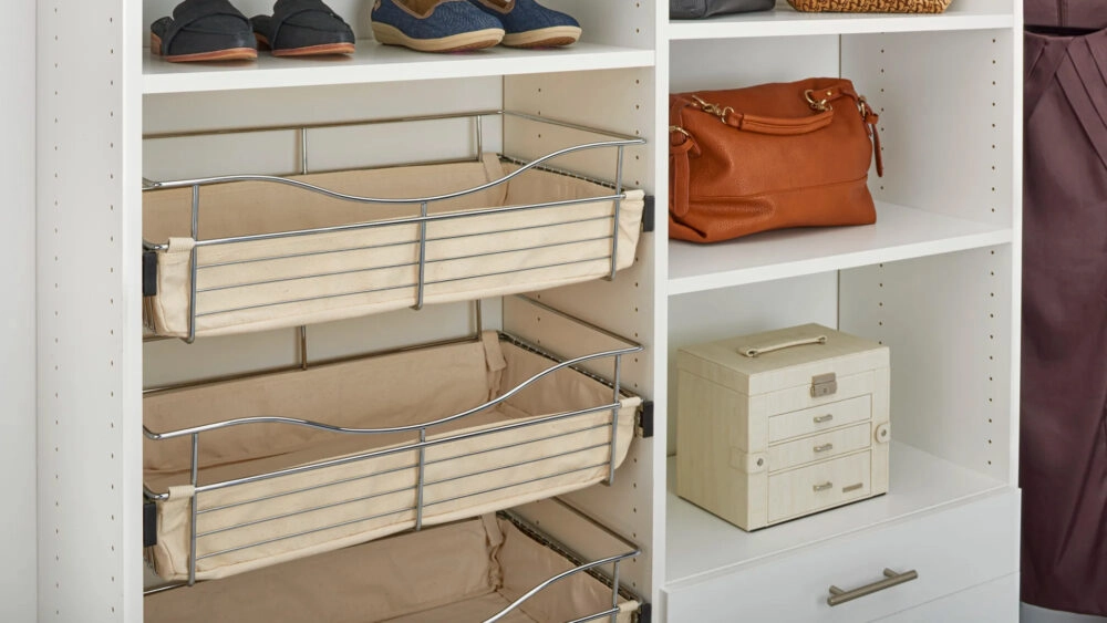 Close up of slidable storage bins in an open shelving section of a closet