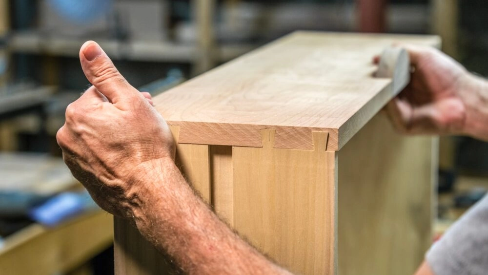 Boards of a cabinet drawer are put together by hand with slotted dado joints