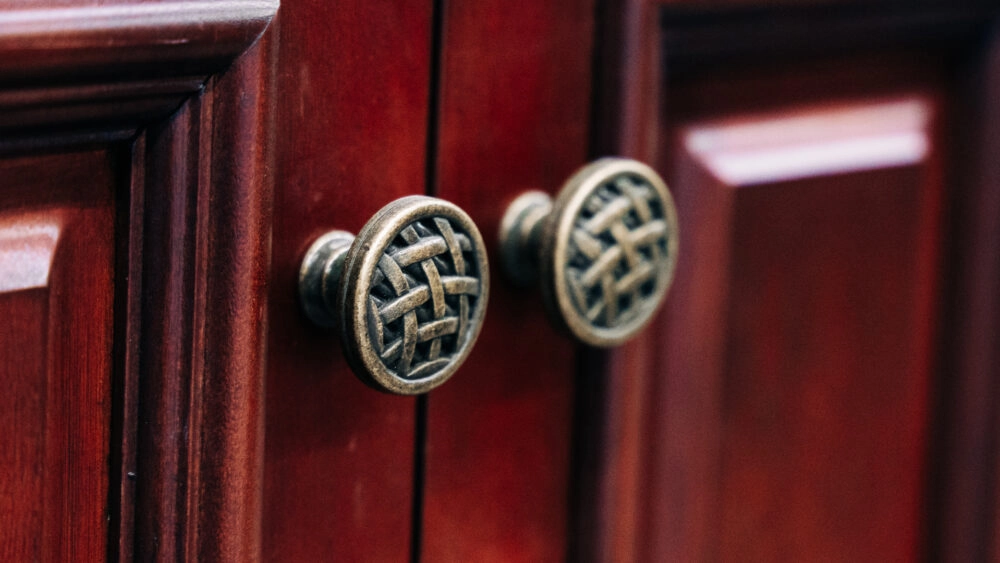 Close up of circle cabinet door knobs with a decorative interwoven basket pattern on the face