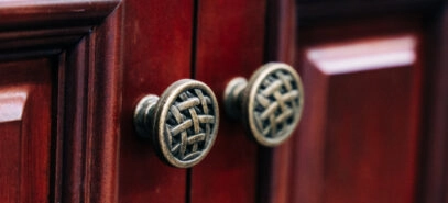 Close up of circle cabinet door knobs with a decorative interwoven basket pattern on the face