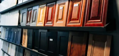A wall of sample cabinet door styles in various wood stains and colors displayed in The Designery showroom