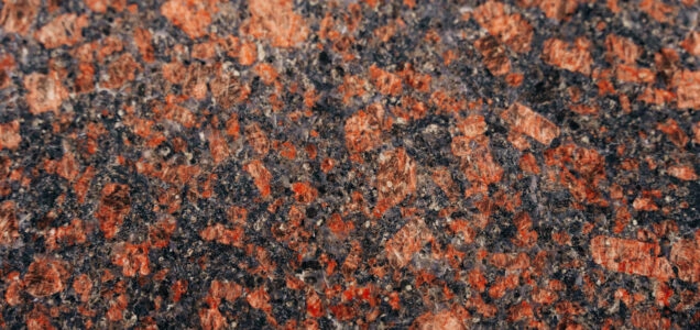 Close up on the pattern of a black granite countertop with copper-red mineral inclusions