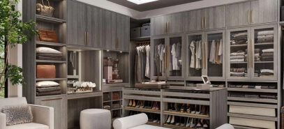 Luxurious, large walk-in closet with floor-to-ceiling closet cabinets for clothing and a storage cabinet island