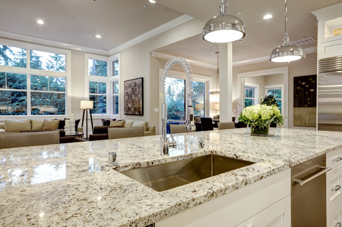 Granite kitchen countertop perfectly accents and contrasts with a white kitchen island.