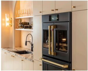 A black and brass double oven next to a matching faucet brings new life to a bright kitchen.