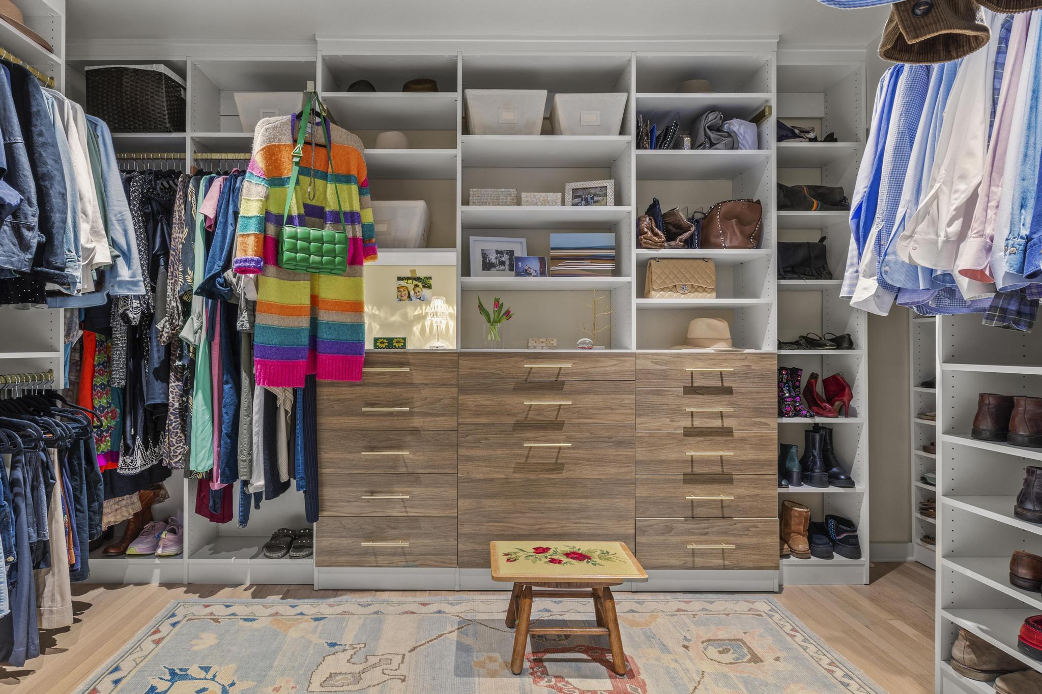 Luxurious, large walk-in closet with floor-to-ceiling closet cabinets for clothing and a storage cabinet island